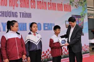 Ông Phạm Đăng Khoa trao tặng máy tính bảng cho học sinh.