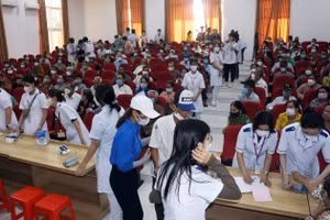 Người dân nghe hướng dẫn làm thủ tục khám bệnh.