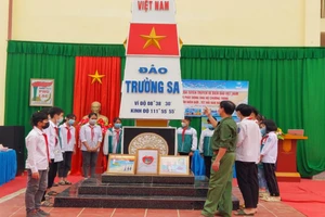 Thầy giáo, cựu chiến binh Lê Đắc Tuấn đang giới thiệu với học sinh về cột mốc chủ quyền biển, đảo Việt Nam.