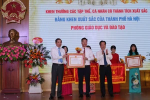 Thừa ủy quyền, TS. Trần Thế Cương - Giám đốc Sở GD&ĐT Hà Nội và ông Hoàng Minh Dũng Tiến - Bí thư Quận ủy Ba Đình trao Bằng khen cho Phòng GD&ĐT quận Ba Đình.