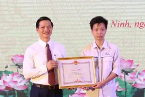 Phó Chủ tịch Thường trực UBND tỉnh Bắc Ninh Vương Quốc Tuấn trao Bằng khen cho em Nguyễn Đăng Phúc.