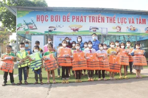 Lãnh đạo Huyện đoàn cùng Ban giám hiệu trường Tiểu học Tân Hưng gửi tặng áo phao và kính bơi của nhà tài trợ cho các em học sinh.