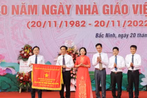 Thừa ủy quyền, Bí thư Tỉnh ủy Bắc Ninh - Nguyễn Anh Tuấn (ngoài cùng bên trái) trao Cờ thi đau của Chính phủ cho Trường THPT Chuyên Bắc Ninh.