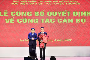 PGS,TS. Nguyễn Duy Bắc, Phó Bí thư Đảng ủy - Phó Giám đốc Thường trực Học viện Chính trị quốc gia Hồ Chí Minh trao quyết định và tặng hoa chúc mừng PGS,TS. Trần Thanh Giang giữ chức Phó Giám đốc Học viện BC&TT.
