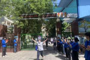 Thanh niên tình nguyện tại điểm thi trường THCS Thăng Long (quận Ba Đình) vỗ tay chúc mừng thí sinh sau khi hoàn thành bài thi cuối cùng. 