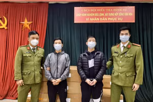 2 đối tượng (đứng giữa) tại cơ quan Công an.