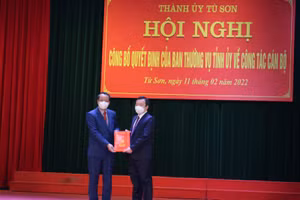 Phó Bí thư Thường trực Tỉnh ủy, Chủ tịch HĐNĐ tỉnh Bắc Ninh Nguyễn Quốc Chung (bên trái) trao quyết định cho tân Phó Bí thư Thành ủy Từ Sơn - Đỗ Tuấn Sơn.