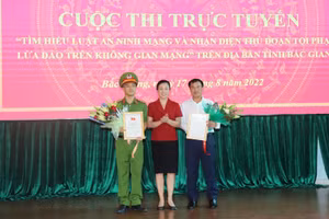 Bà Lê Thị Thu Hồng - Chủ tịch HĐND tỉnh Bắc Giang trao hoa, Giấy chứng nhận giải Nhất cho huyện Việt Yên và Thiếu tá Nguyễn Ngọc Minh, Trưởng Công an xã Tân Liễu (Ảnh BBG).