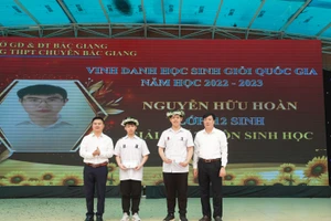 Phó Giám đốc Sở GD&ĐT Bắc Giang - Bạch Đăng Khoa (bên trái ngoài cùng) và thầy Trần Duy Phương - Hiệu trưởng trường THPT Chuyên Bắc Giang khen thưởng cho học sinh.