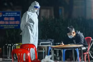 Lực lượng y tế làm việc với các F1 ở huyện Đông Anh để đưa đi cách ly rạng sáng 30/4. Ảnhh: Giang Huy.