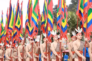 100 thanh niên tượng trưng cho con Lạc, cháu Hồng trong trang phục cổ, tay giương cao cờ hội, thể hiện sức sống mãnh liệt của dòng giống Tiên Rồng. (Ảnh: Thống Nhất/TTXVN).