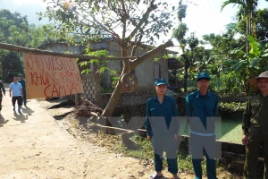 Lực lượng dân quân xã Hạ Bì canh gác không cho người dân đi vào vùng sạt lở nguy hiểm. (Ảnh: Nhan Sinh/TTXVN)