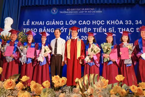 PGS.TS Trần Hoàng Hải - Quyền Hiệu trưởng Nhà trường (giữa) trao bằng Tiến sĩ cho các học viên