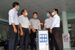 TS Nguyễn Văn Hiếu- bìa phải khi tặng máy rửa tay thông minh cho bệnh viện Quận 9, TPHCM