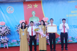 Thừa quyền Chủ tịch nước CHXHCN Việt Nam, Bí thư Thành ủy Dương Tất Thắng (bên phải) trao Bằng công nhận Huân chương Lao động hạng Nhất cho nhà trường.