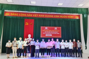 Lãnh đạo tỉnh Hà Tĩnh, lãnh đạo Trường Đại học Huế trao những suất quà cho 2 em Nguyên và Hoàng tại buổi lễ.