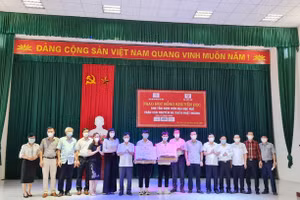 Lãnh đạo tỉnh Hà Tĩnh, lãnh đạo Trường Đại học Huế trao những suất quà cho 2 em Nguyên và Hoàng tại buổi lễ.