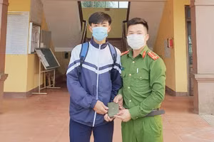 Em Đặng Gia Bảo bàn giao số tiền cho công an xã.