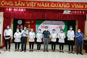 Thầy Nguyễn Văn Quang - Hiệu trưởng Trường THPT Cẩm Bình trao điện thoại cho các học sinh.