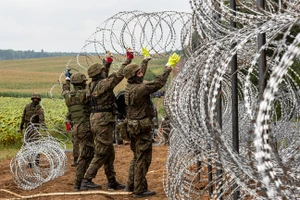 Lính Ba Lan dựng hàng rào bằng dây kẽm gai ở biên giới Belarus. (Ảnh: Getty Images)