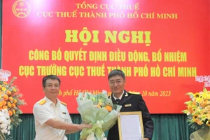 Ông Nguyễn Nam Bình (phải) nhận quyết định điều động, bổ nhiệm làm Cục trưởng Cục Thuế TPHCM. (Ảnh: Thành ủy TPHCM)