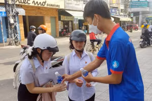 Thanh niên tình nguyện phát nước cho thí sinh tại điểm thi Trường THCS Trưng Vương. Ảnh: NTCC