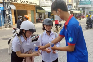 Thanh niên tình nguyện phát nước cho thí sinh tại điểm thi Trường THCS Trưng Vương. Ảnh: NTCC