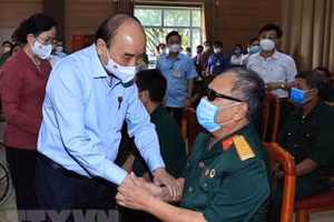 Chủ tịch nước Nguyễn Xuân Phúc thăm hỏi thương bệnh binh tại Trung tâm nuôi dưỡng bệnh binh nặng và Điều dưỡng người có công tỉnh Hà Nam. Ảnh: TTXVN.