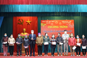 TS Nguyễn Đắc Trung, Phó Bí thư Đảng uỷ, Chủ tịch Hội đồng trường đại học Y - Dược và ông Trần Đức Tú, Phó Bí thường trực Đảng uỷ xã La Hiên trao quà tặng cho các gia đình chính sách và hộ nghèo tại địa phương.