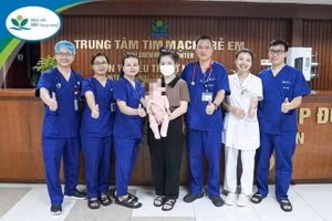 Hai mẹ con bé P.S chụp ảnh lưu niệm cùng các y bác sĩ Trung tâm Tim mạch, Bệnh viện Nhi Trung ương. Ảnh: BV.