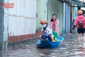 Một phụ huynh đưa con đến trường bằng xuồng.