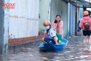 Một phụ huynh đưa con đến trường bằng xuồng.