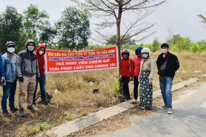 Khách hàng căng băng rôn yêu cầu ông Bùi Vĩnh Tuấn trả lại tiền.