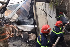 Lực lượng chức năng tiến hành cứu hỏa tại hiện trường vụ án.