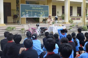 Công an huyện Tiên Yên hướng dẫn cho các em học sinh những kỹ năng đội mũ bảo hiểm an toàn.