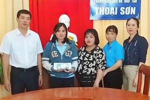 Thầy Nguyễn Anh Tuấn - Phó trưởng Phòng GD&ĐT Thoại Sơn chuyển trao tiền của đồng nghiệp cùng các nhà hảo tâm và bạn đọc Báo GD&TĐ cho cô Đỗ Thị Thanh Thẩm. 