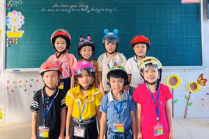 Học sinh lớp 2 thực hành đội mũ bảo hiểm an toàn, theo đúng quy định.