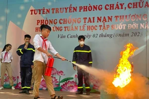 Học sinh Trường THCS Vân Canh thực hành kỹ năng sử dụng bình chữa cháy mini để dập tắt đám cháy giả định. 