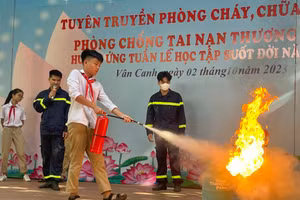 Học sinh Trường THCS Vân Canh thực hành kỹ năng sử dụng bình chữa cháy mini để dập tắt đám cháy giả định. 