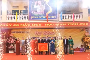 Đại diện Trường THCS Phú Diễn đón nhận Cờ thi đua của Chính phủ từ lãnh đạo UBND quận Bắc Từ Liêm tại lễ kỷ niệm. 