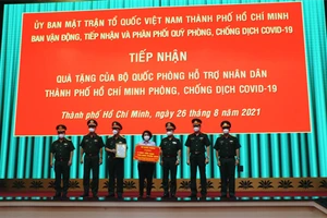 Lãnh đạo TP. HCM tiếp nhận phần quà biểu trưng.