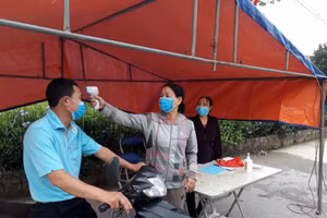 Kiểm tra thân nhiệt, thực hiện phòng dịch Covid-19 tại chốt phòng dịch Covid-19 tại huyện Đông Anh.