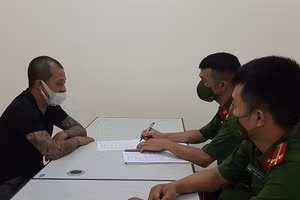 Lực lượng chức năng thiết lập hồ sơ xử phạt nam thanh niên (áo đen) vi phạm quy định phòng dịch.