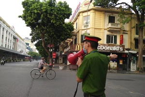 Công an quận Hoàn Kiếm tuyên truyền, nhắc nhở người dân không ra khỏi nhà khi không cần thiết.