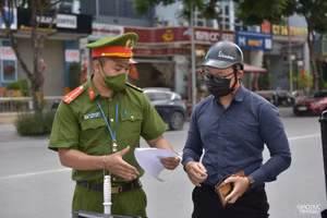 Lực lượng chức năng tuyên truyền nhắc nhở người dân thực hiện nghiêm quy định phòng dịch (Ảnh Thế Đại).