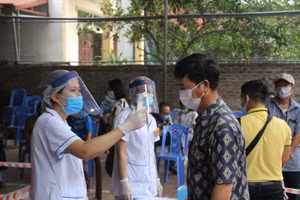 Lực lượng y tế kiểm tra thân nhiệt cho người dân phồng dịch Covid-19.