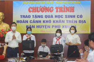 Trưởng phòng GD&ĐT quận Ba Đình Lê Đức Thuận (bên trái ngoài cùng) trao tặng máy tính cho học sinh khó khăn huyện Phú Xuyên.