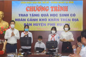 Trưởng phòng GD&ĐT quận Ba Đình Lê Đức Thuận (bên trái ngoài cùng) trao tặng máy tính cho học sinh khó khăn huyện Phú Xuyên.