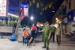 Lực lượng chức năng tuyên truyền nhắc nhở người dân thực hiện nghiêm công tác phòng dịch Covid-19.
