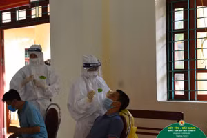 Lực lượng y tế lấy mẫu xét nghiệm Covid-19 cho công nhân.